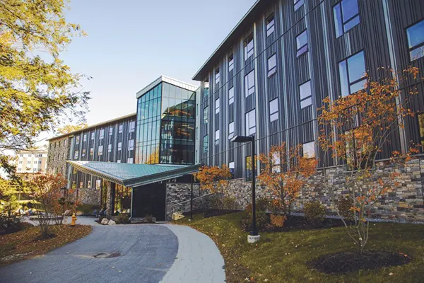 A SNHU campus building shown in the fall with brightly colored leaves.